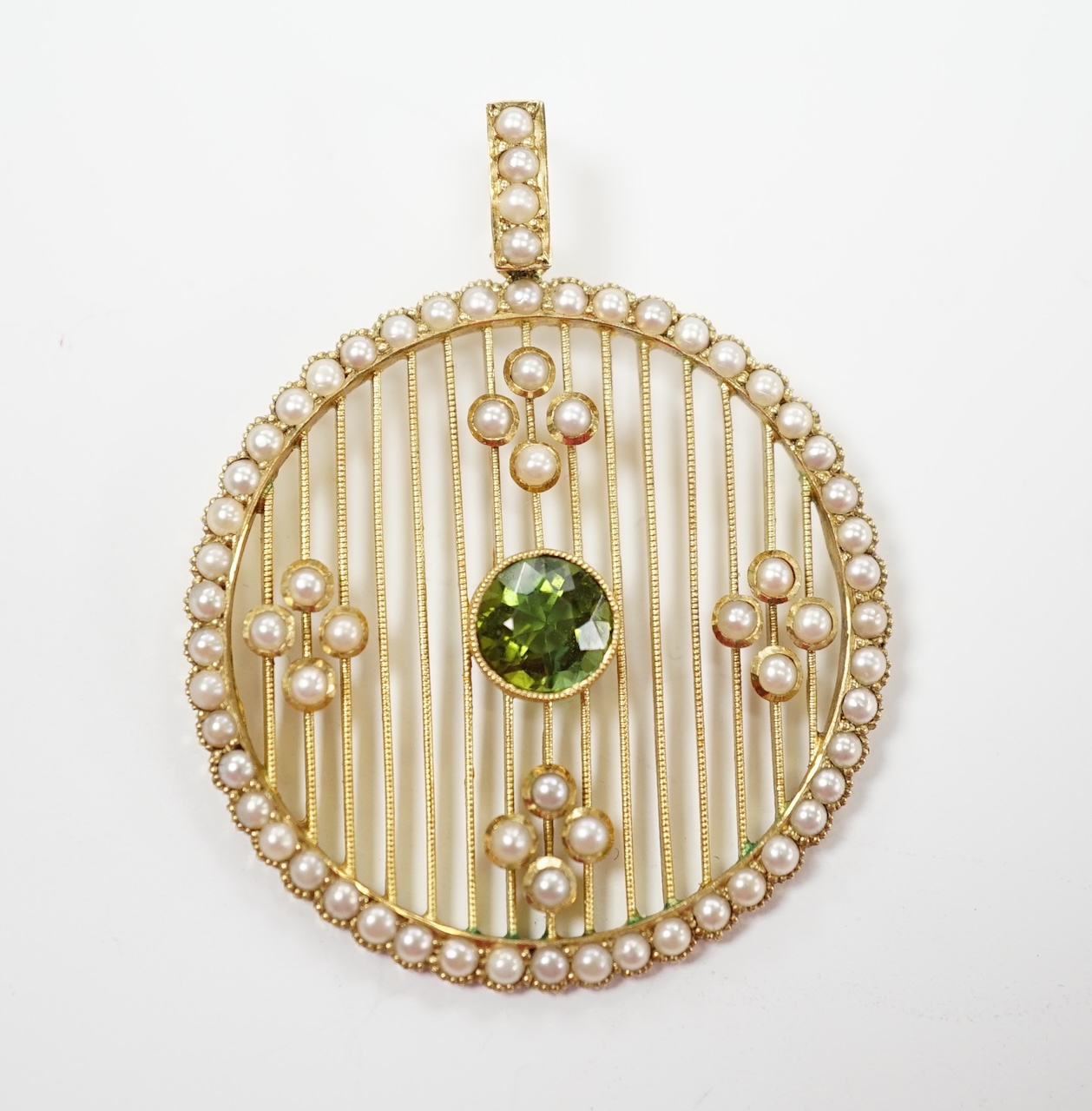 An Edwardian 15ct, green tourmaline and seed pearl cluster set circular pearl pendant, overall 41mm, gross weight 7 grams.